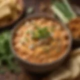 A creamy buffalo chicken dip in a rustic bowl garnished with fresh herbs